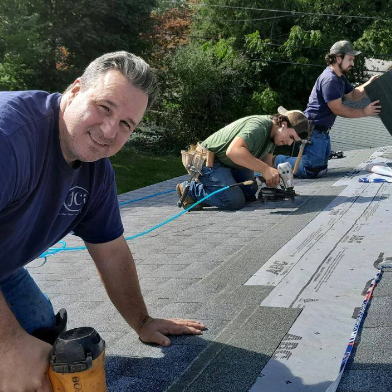 roofers installing new asphalt roof shingle
